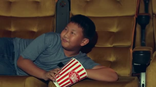 El chico está tumbado viendo películas. — Vídeos de Stock