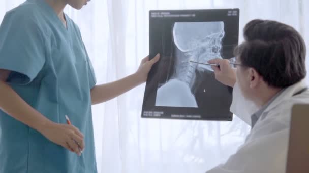 Arts en verpleegkundige bespreken over chirurgie resultaat tonen op x-ray beeld van het hoofd van de patiënt. — Stockvideo