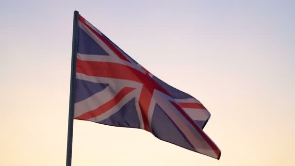 Britse vlag zwaaiend over zonsondergang hemel. — Stockvideo