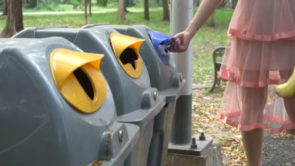 Jongeren vrijwilligers gooien afval in vuilnisbak. — Stockvideo