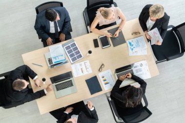 İş adamları grup toplantısı ofiste yukarıdan çekildi. İş kadınları, iş adamları ve ofis çalışanları, proje planlama belgeleriyle takım konferansında toplantı masasında çalışıyorlar. .