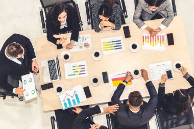 İş adamları grup toplantısı ofiste yukarıdan çekildi. İş kadınları, iş adamları ve ofis çalışanları, proje planlama belgeleriyle takım konferansında toplantı masasında çalışıyorlar. .