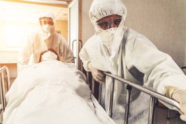 Acil servis doktoru ve doktor hastayı hastanedeki acil servise götürüyor. Doktor koronavirüs ve covid 19 koruma ve karantina kavramında koruyucu giysi ve yüz maskesi takıyor. .