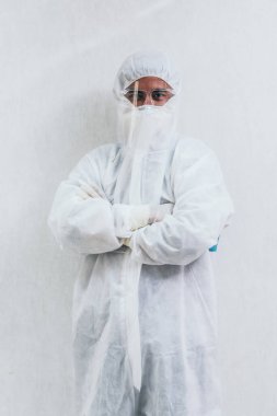 Koronavirüs ve Covid-19 enfeksiyonundan korunan hastane koğuşunda yüz maskesi ve yüz maskesi takan doktor. .