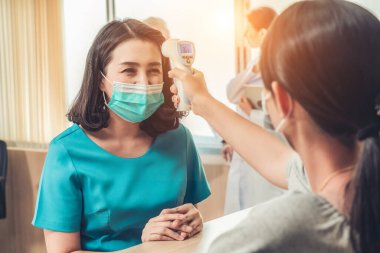 Ofiste ya da hastanede konuşurken resepsiyonist ve misafir maske takıyor. Covid 19 ve Coronavirus enfeksiyon koruması ve koruma politikası kavramı .