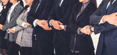 Başarılı iş adamları, işçi toplumunun güçlü ilişkilerini göstermek için bir arada duruyorlar. Modern ofiste güçlü bir takım çalışması sergileyen iş adamı ve iş kadınlarından oluşan bir ekip..