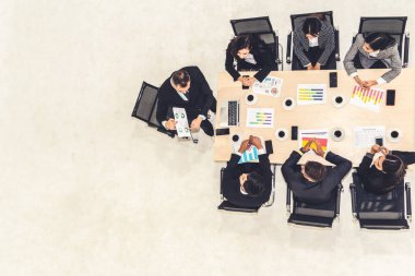 İş adamları grup toplantısı ofiste yukarıdan çekildi. İş kadınları, iş adamları ve ofis çalışanları, proje planlama belgeleriyle takım konferansında toplantı masasında çalışıyorlar. .