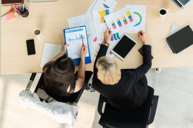 İş adamları grup toplantısı ofiste yukarıdan çekildi. İş kadınları, iş adamları ve ofis çalışanları, proje planlama belgeleriyle takım konferansında toplantı masasında çalışıyorlar. .