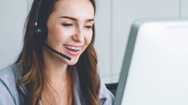 Ofiste çalışan kulaklık takan işadamları uzak müşteri ya da meslektaşlarını desteklemek için çalışıyorlar. Arama merkezi, tele pazarlama, müşteri destek acentesi telefon görüşmesinde hizmet sunar.