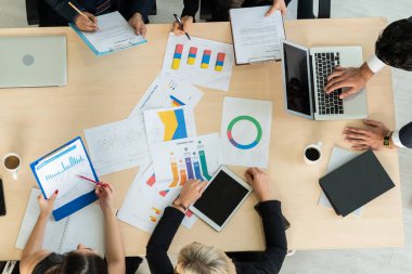 İş adamları grup toplantısı ofiste yukarıdan çekildi. İş kadınları, iş adamları ve ofis çalışanları, proje planlama belgeleriyle takım konferansında toplantı masasında çalışıyorlar. .