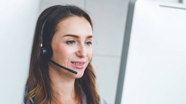Ofiste çalışan kulaklık takan işadamları uzak müşteri ya da meslektaşlarını desteklemek için çalışıyorlar. Arama merkezi, tele pazarlama, müşteri destek acentesi telefon görüşmesinde hizmet sunar.