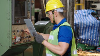 Fabrika atölyesinde makine kullanan akıllı bir fabrika işçisi. Endüstri ve mühendislik kavramı.