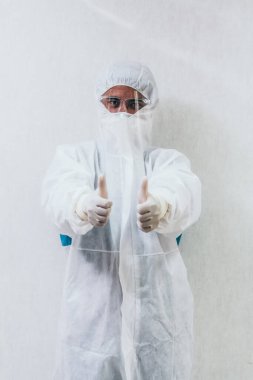 Koronavirüs ve Covid-19 enfeksiyonundan korunan hastane koğuşunda yüz maskesi ve yüz maskesi takan doktor. .