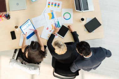 İş adamları grup toplantısı ofiste yukarıdan çekildi. İş kadınları, iş adamları ve ofis çalışanları, proje planlama belgeleriyle takım konferansında toplantı masasında çalışıyorlar. .