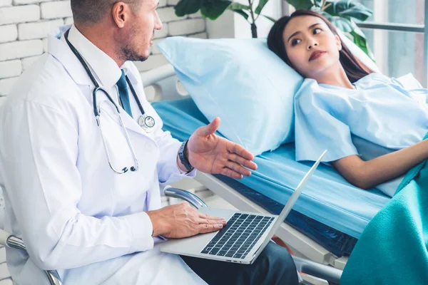 Profesyonel üniformalı doktor hastanedeki ya da klinikteki hastayı muayene ediyor. Sağlık, sağlık ve doktor hizmetleri konsepti.