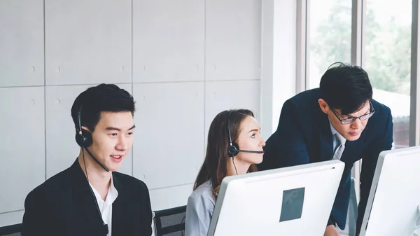 Business people wearing headset working in office to support remote customer or colleague. Call center, telemarketing, customer support agent provide service on telephone video conference call.