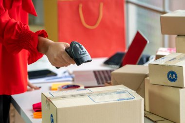 Çevrimiçi satıcı ev ofisinde çalışıyor ve teslimat kutusunu müşteriye paketliyor. İnternette e-ticaret yapan küçük işletme sahibi ya da girişimci.