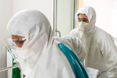 Acil servis doktoru ve doktor hastayı hastanedeki acil servise götürüyor. Doktor koronavirüs ve covid 19 koruma ve karantina kavramında koruyucu giysi ve yüz maskesi takıyor. .