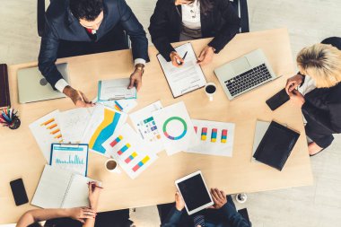İş adamları grup toplantısı ofiste yukarıdan çekildi. İş kadınları, iş adamları ve ofis çalışanları, proje planlama belgeleriyle takım konferansında toplantı masasında çalışıyorlar. .
