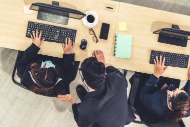 Ofiste üst kademeden kulaklık takan işadamları uzak müşteri ya da meslektaşlarını desteklemek için bilgisayarla çalışıyorlar. Çağrı merkezi, tele pazarlama acente servisi telefon ya da video konferans çağrısı.
