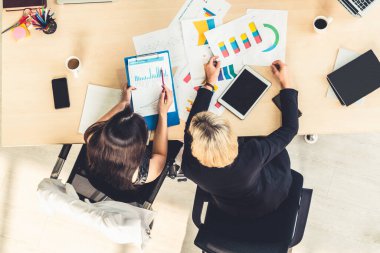 İş adamları grup toplantısı ofiste yukarıdan çekildi. İş kadınları, iş adamları ve ofis çalışanları, proje planlama belgeleriyle takım konferansında toplantı masasında çalışıyorlar. .