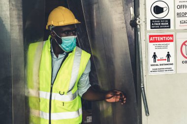 Fabrika işçileri için uyarı levhası Covid-19 Coronavirus 'un salgın krizinden sonra tekrar açılmasını önlemek için. Güvenli çalışma kavramı .