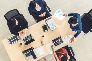 İş adamları grup toplantısı ofiste yukarıdan çekildi. İş kadınları, iş adamları ve ofis çalışanları, proje planlama belgeleriyle takım konferansında toplantı masasında çalışıyorlar. .