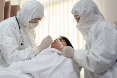 Doktor, hastadan kovid 19 veya koronavirüs enfeksiyonunu test etmek için Nasofaringeal numune aldı. Covid-19 Tıbbi Muayene Personel Hizmeti .
