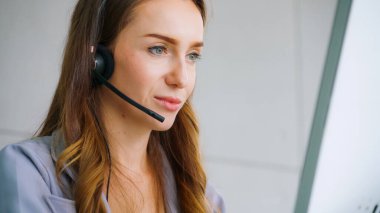 Ofiste çalışan kulaklık takan işadamları uzak müşteri ya da meslektaşlarını desteklemek için çalışıyorlar. Arama merkezi, tele pazarlama, müşteri destek acentesi telefon görüşmesinde hizmet sunar.