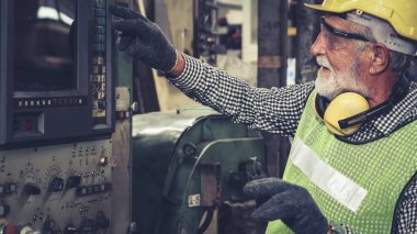 Fabrika atölyesinde makine kullanan akıllı bir fabrika işçisi. Endüstri ve mühendislik kavramı.