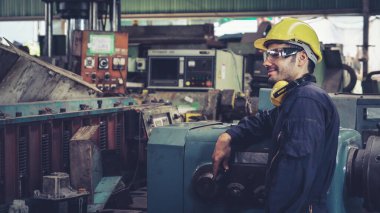 Fabrika atölyesinde makine kullanan akıllı bir fabrika işçisi. Endüstri ve mühendislik kavramı.