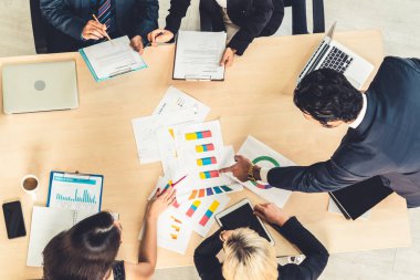 İş adamları grup toplantısı ofiste yukarıdan çekildi. İş kadınları, iş adamları ve ofis çalışanları, proje planlama belgeleriyle takım konferansında toplantı masasında çalışıyorlar. .