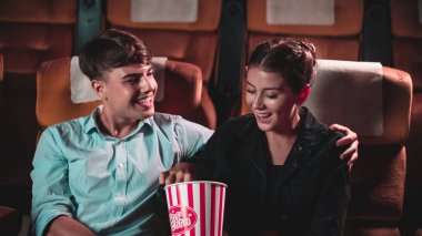 Erkekler ve kadınlar tiyatroda patlamış mısır yemek ve atmak eğlenceliydi.