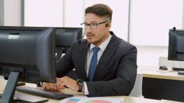 Ofiste çalışan kulaklık takan işadamları uzak müşteri ya da meslektaşlarını desteklemek için çalışıyorlar. Arama merkezi, tele pazarlama, müşteri destek acentesi telefon görüşmesinde hizmet sunar.