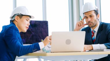 Mühendis ve mimar, mühendislik ve mimari proje planlaması hakkında ofis masasında bir araya geldiler. .