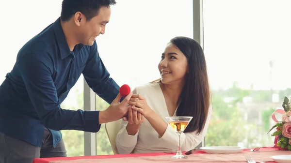 Romantic couple giving gift to lover at restaurant — Stock Photo, Image