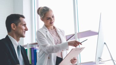 İki iş adamı ofiste proje stratejisi hakkında konuşuyor