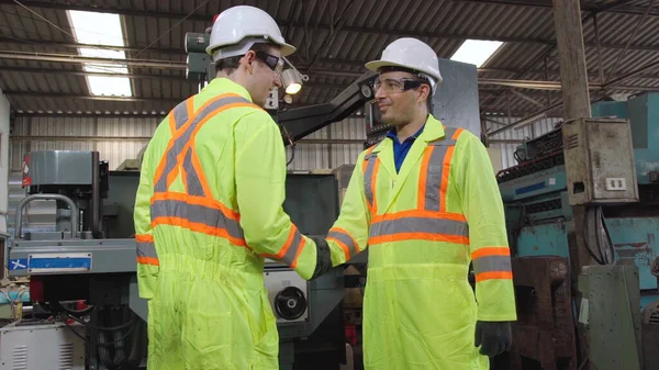 Factory workers handshake with team member in the factory