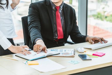 İki iş adamı ofiste proje stratejisi hakkında konuşuyor