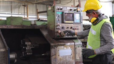 Fabrika atölyesinde makine kullanan akıllı bir fabrika işçisi