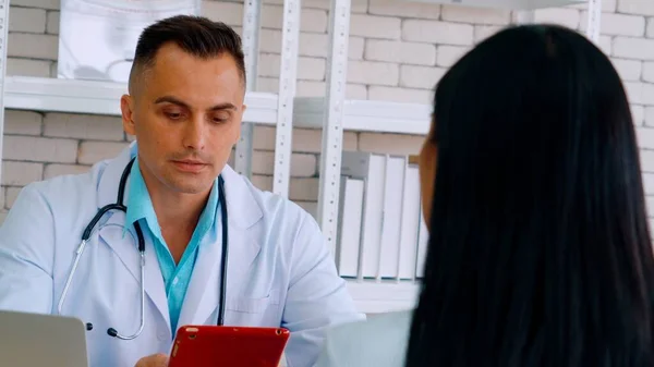 Doutor em uniforme profissional examinando paciente no hospital — Fotografia de Stock