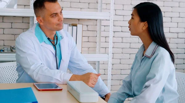 Doutor em uniforme profissional examinando paciente no hospital — Fotografia de Stock