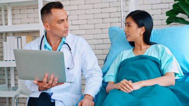 Profesyonel üniformalı doktor hastanedeki hastayı muayene ediyor.