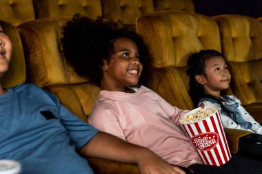 Üç çocuk film izlerken eğleniyor.