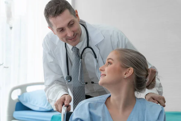 Doutor em uniforme profissional examinando paciente no hospital — Fotografia de Stock