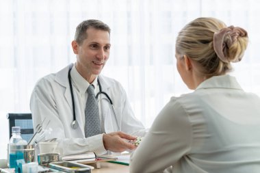 Profesyonel üniformalı doktor hastanedeki hastayı muayene ediyor.