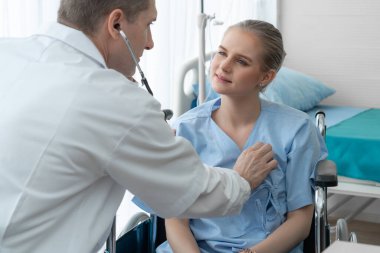 Profesyonel üniformalı doktor hastanedeki hastayı muayene ediyor.