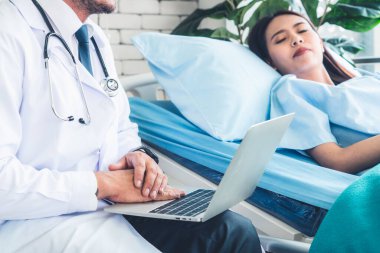 Profesyonel üniformalı doktor hastanedeki hastayı muayene ediyor.