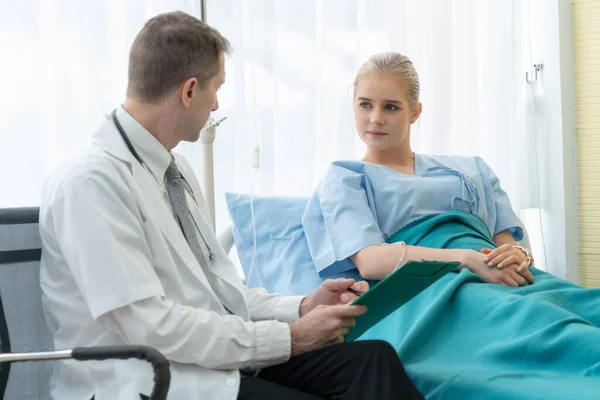 Doutor em uniforme profissional examinando paciente no hospital — Fotografia de Stock