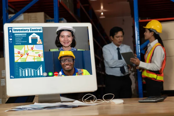 Warehouse staff talking on video call at computer screen in storage warehouse — Stock Photo, Image